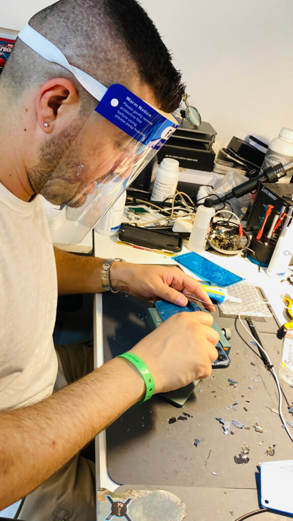 Tecnico al banco durante una riparazione di smartphone nel laboratorio